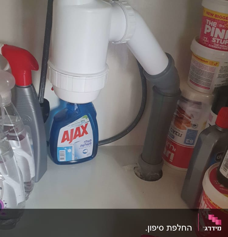 צינור ניקוז לבן מתחת לכיור עם חיבורים